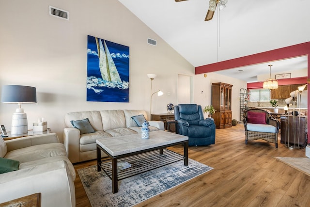 112 Cove Pt, Montgomery, TX 77356 - living area with light wood-style floors, high vaulted ceiling, a ceiling fan, and a chandelier