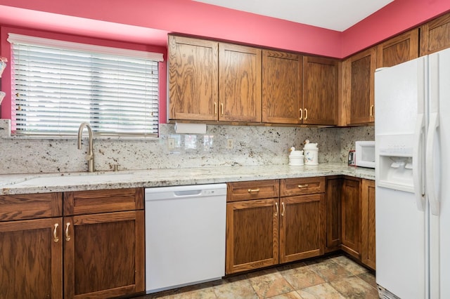 112 Cove Pt, Montgomery, TX 77356 - kitchen with white appliances, a sink, light stone countertops, stone finish flooring, and tasteful backsplash