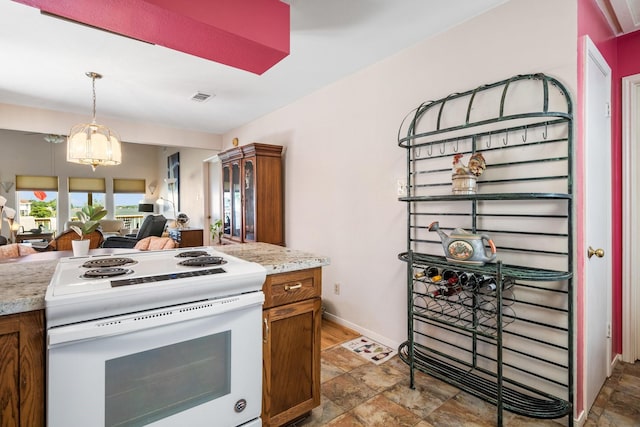 112 Cove Pt, Montgomery, TX 77356 - kitchen with white electric stove, stone finish floors, open floor plan, and a chandelier
