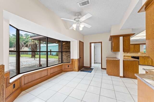1211 Sycamore Ln, Houston, TX 77339 - kitchen featuring brown cabinetry, a textured ceiling, ceiling fan, light countertops, and light tile patterned floors