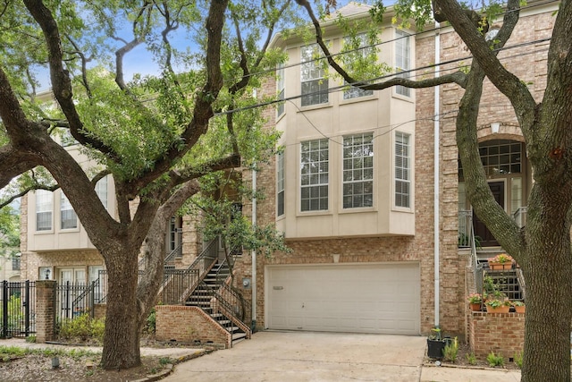 2007 Indiana St, Houston, TX 77019 - view of front of home featuring a garage, concrete driveway, stucco siding, and brick siding