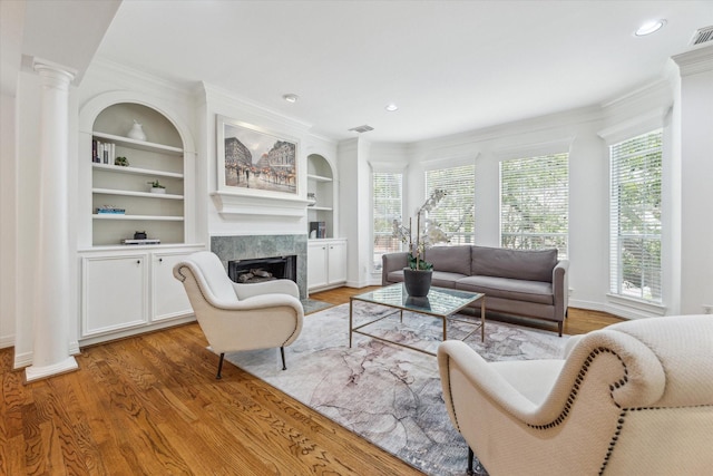 2007 Indiana St, Houston, TX 77019 - living area featuring decorative columns, a high end fireplace, light wood-type flooring, baseboards, and built in shelves