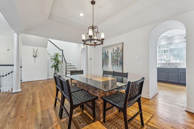 2007 Indiana St, Houston, TX 77019 - dining area with arched walkways, a raised ceiling, light wood-style flooring, a chandelier, and stairway