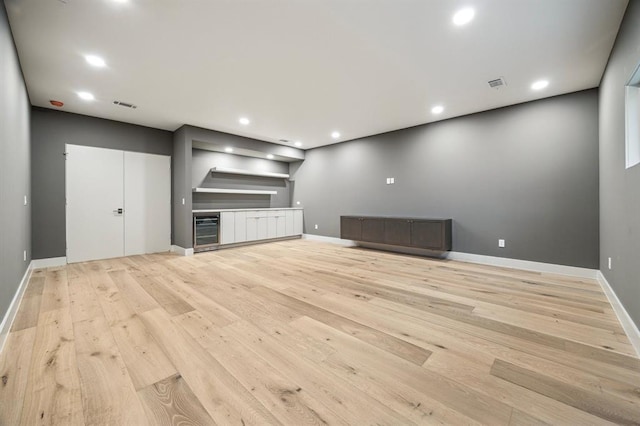 2129 Quenby St, Houston, TX 77005 - unfurnished living room with wine cooler, light wood finished floors, baseboards, and recessed lighting