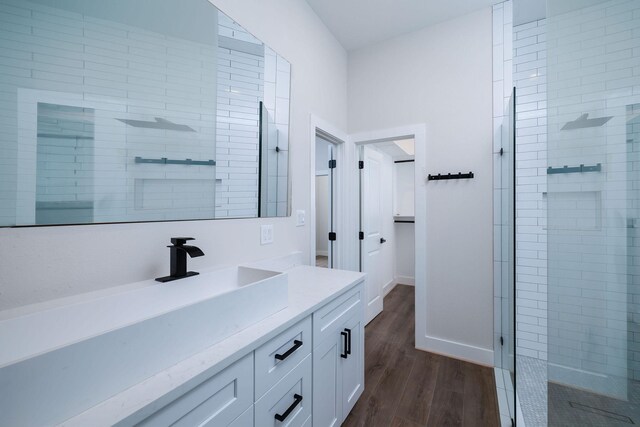 354 Peach Point Ln, Trinity, TX 75862 - bathroom with vanity, tiled shower, wood finished floors, and baseboards