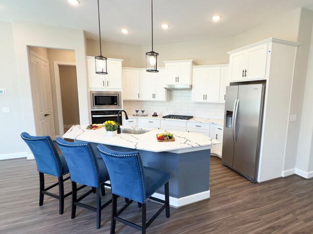 1306 Hidden Oaks Dr, Tomball, TX 77375 - kitchen featuring appliances with stainless steel finishes, a sink, baseboards, dark wood finished floors, and tasteful backsplash