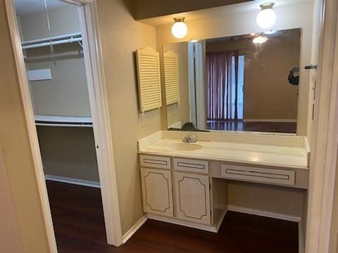 6662 Canyon Way Dr, Houston, TX 77086 - bathroom featuring wood finished floors, vanity, a walk in closet, and baseboards