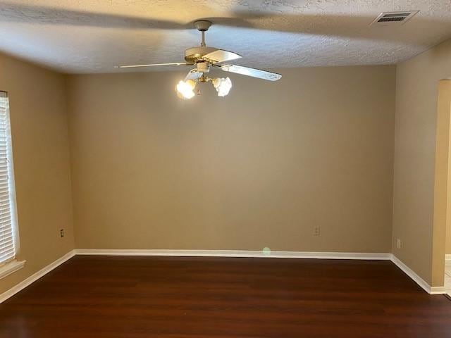 6662 Canyon Way Dr, Houston, TX 77086 - unfurnished room with dark wood-style floors, ceiling fan, baseboards, and a textured ceiling
