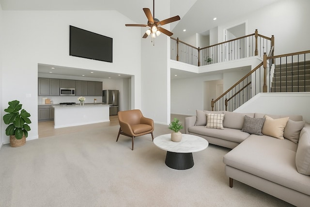 5462 Grand View Dr, Fulshear, TX 77423 - living room featuring high vaulted ceiling, a ceiling fan, light colored carpet, stairs, and recessed lighting