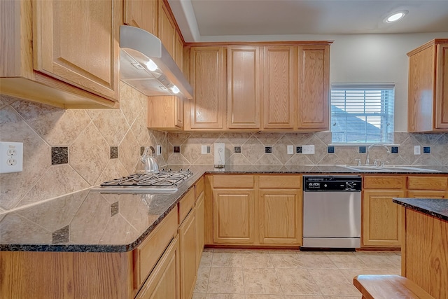 20810 Mansfield Bay Ln, Richmond, TX 77407 - kitchen with stainless steel appliances, exhaust hood, a sink, tasteful backsplash, and dark stone counters