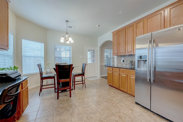20810 Mansfield Bay Ln, Richmond, TX 77407 - kitchen featuring stainless steel fridge with ice dispenser, arched walkways, a chandelier, tasteful backsplash, and baseboards