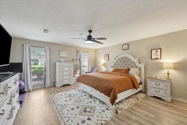 504 County Road 763 N, Buna, TX 77612 - bedroom with multiple windows, light wood finished floors, ceiling fan, baseboards, and a textured ceiling