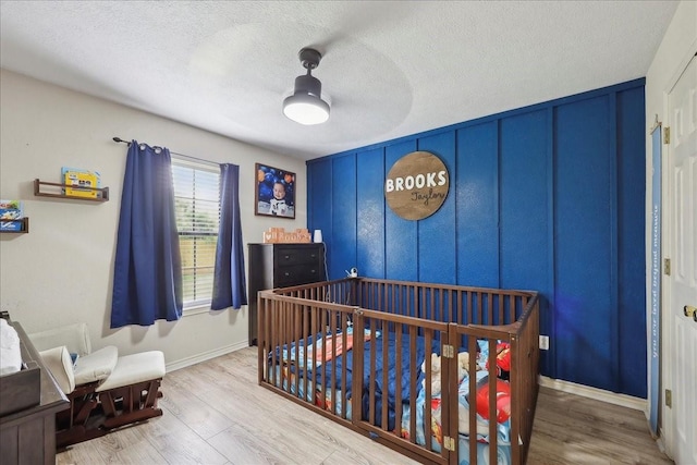 504 County Road 763 N, Buna, TX 77612 - bedroom featuring wood finished floors, a textured ceiling, baseboards, and a crib