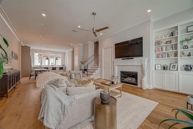 5213 Feagan St Unit H, Houston, TX 77007 - living room featuring ceiling fan, ornamental molding, a fireplace, built in shelves, and light wood-style floors