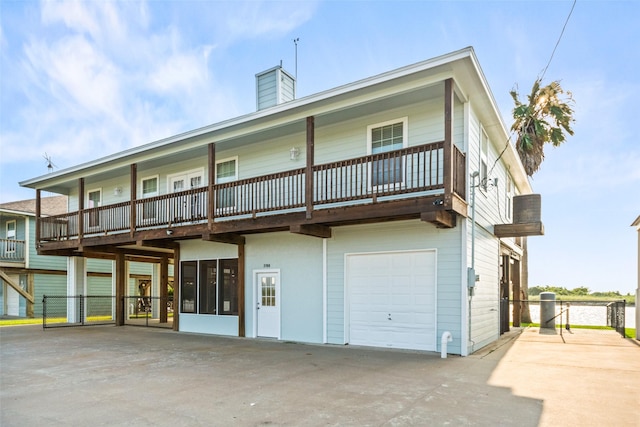 3190 Fm-2031, Matagorda, TX 77414 - rear view of property featuring an attached garage, a chimney, and driveway