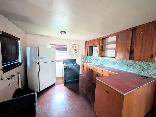 622 Gazin St, Houston, TX 77020 - kitchen featuring freestanding refrigerator, gas range, brown cabinets, open shelves, and dark flooring