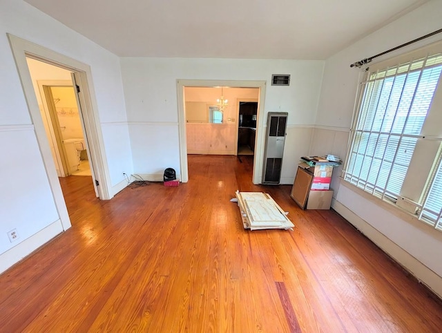 622 Gazin St, Houston, TX 77020 - empty room featuring a heating unit, a chandelier, wood finished floors, and baseboards