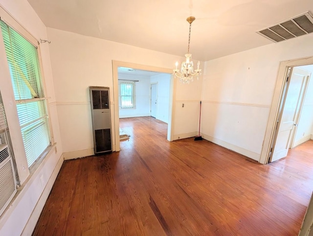 622 Gazin St, Houston, TX 77020 - unfurnished dining area with a heating unit, a chandelier, wood finished floors, and baseboards