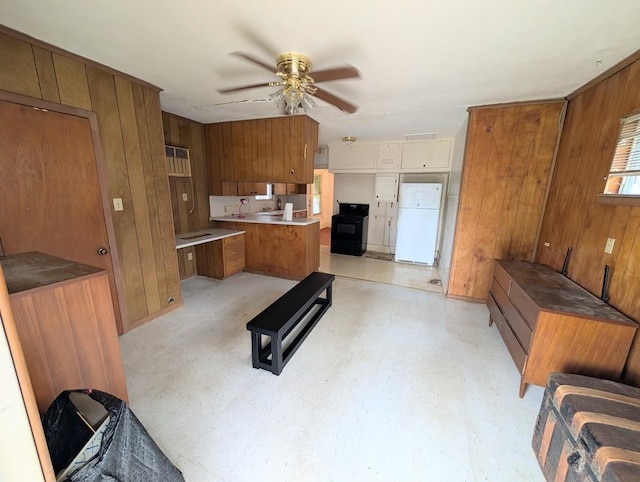 622 Gazin St, Houston, TX 77020 - kitchen with freestanding refrigerator, brown cabinetry, black range with electric cooktop, a ceiling fan, and wood walls
