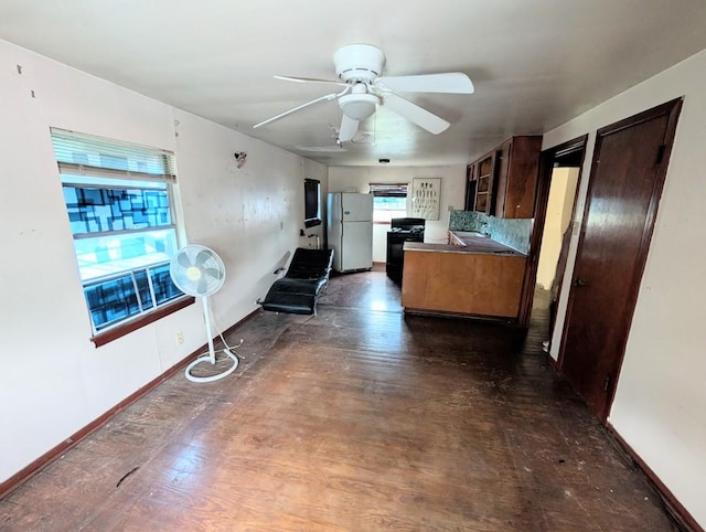 622 Gazin St, Houston, TX 77020 - kitchen with freestanding refrigerator, black gas stove, a ceiling fan, baseboards, and dark brown cabinets