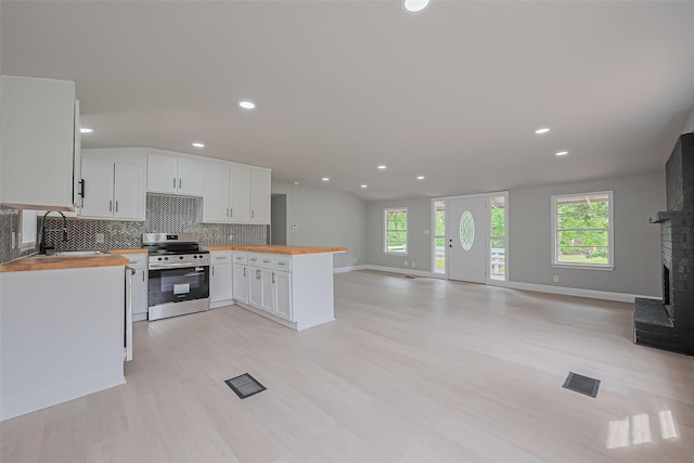 131 Holiday Blvd, Coldspring, TX 77331 - kitchen featuring stainless steel electric range oven, wooden counters, a sink, a peninsula, and open floor plan