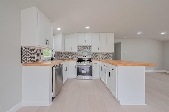 131 Holiday Blvd, Coldspring, TX 77331 - kitchen with butcher block countertops, stainless steel appliances, a sink, a peninsula, and recessed lighting