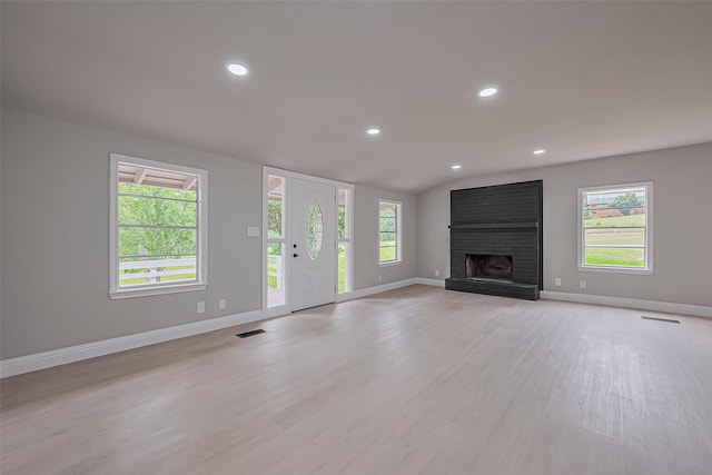131 Holiday Blvd, Coldspring, TX 77331 - unfurnished living room featuring baseboards, light wood-type flooring, a fireplace, recessed lighting, and healthy amount of natural light