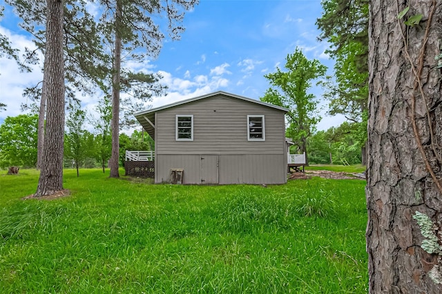131 Holiday Blvd, Coldspring, TX 77331 - view of side of home featuring a lawn and a wooden deck