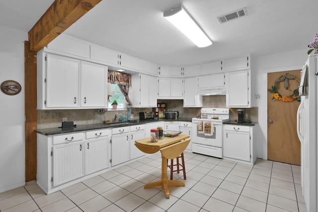 9141 Oak Arbor Dr, Conroe, TX 77384 - kitchen featuring white appliances, under cabinet range hood, decorative backsplash, dark countertops, and white cabinetry
