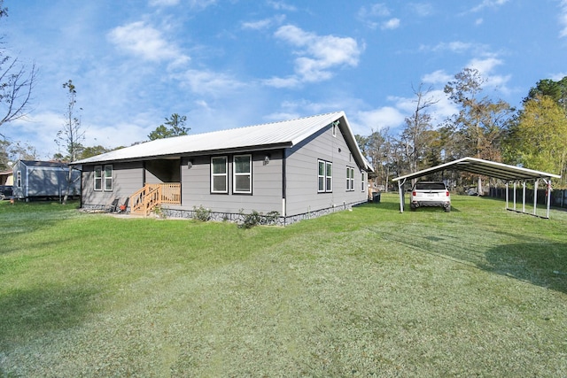 20695 Liberty St, New Caney, TX 77357 - view of front of home with a detached carport, entry steps, a front yard, and metal roof