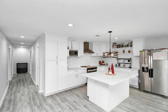 20695 Liberty St, New Caney, TX 77357 - kitchen with stainless steel appliances, wall chimney range hood, light wood-type flooring, open shelves, and white cabinets