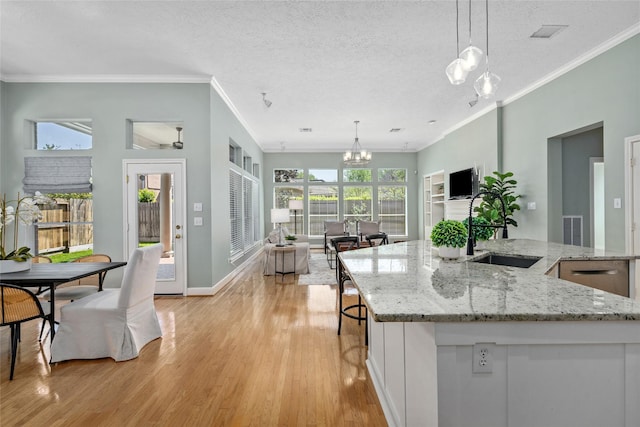 1107 Walden Hill Ct, Houston, TX 77077 - kitchen featuring a sink, a chandelier, light wood finished floors, open floor plan, and ornamental molding