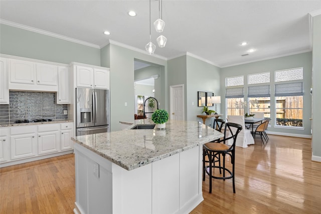 1107 Walden Hill Ct, Houston, TX 77077 - kitchen featuring stainless steel refrigerator with ice dispenser, a sink, light wood-style flooring, backsplash, and light stone counters