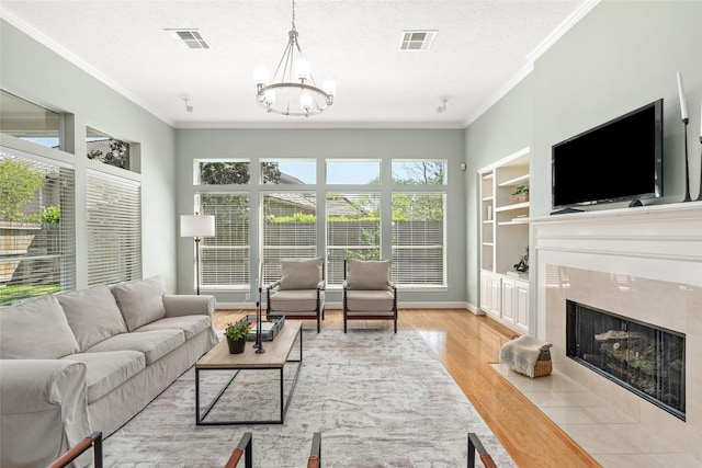1107 Walden Hill Ct, Houston, TX 77077 - living room featuring crown molding, a chandelier, light wood-type flooring, a high end fireplace, and a textured ceiling