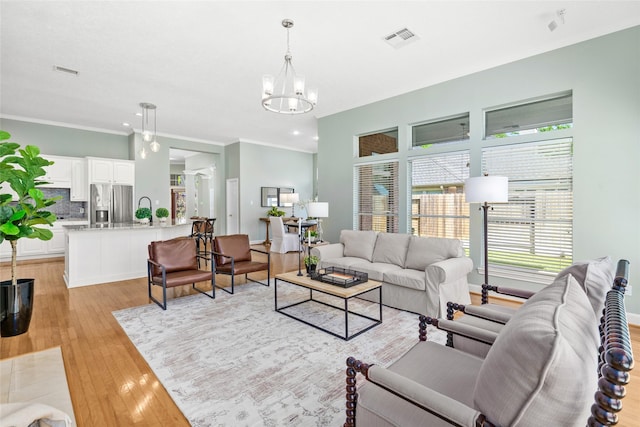 1107 Walden Hill Ct, Houston, TX 77077 - living room featuring a chandelier, light wood-style flooring, crown molding, and recessed lighting