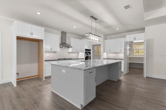 28200 E Stallion Ln, Waller, TX 77484 - kitchen featuring wall chimney range hood, decorative backsplash, white cabinetry, a kitchen island with sink, and recessed lighting