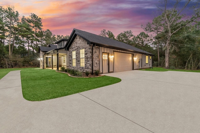 28200 E Stallion Ln, Waller, TX 77484 - view of front of property featuring stone siding, driveway, a lawn, an attached garage, and board and batten siding