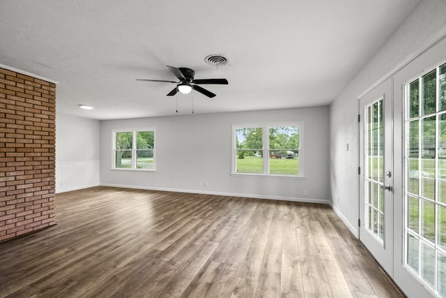 606 Clayton St, Tomball, TX 77375 - spare room featuring wood finished floors, plenty of natural light, a ceiling fan, brick wall, and french doors
