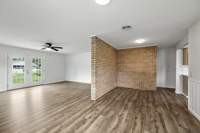 606 Clayton St, Tomball, TX 77375 - unfurnished living room with brick wall, wood finished floors, a ceiling fan, french doors, and baseboards