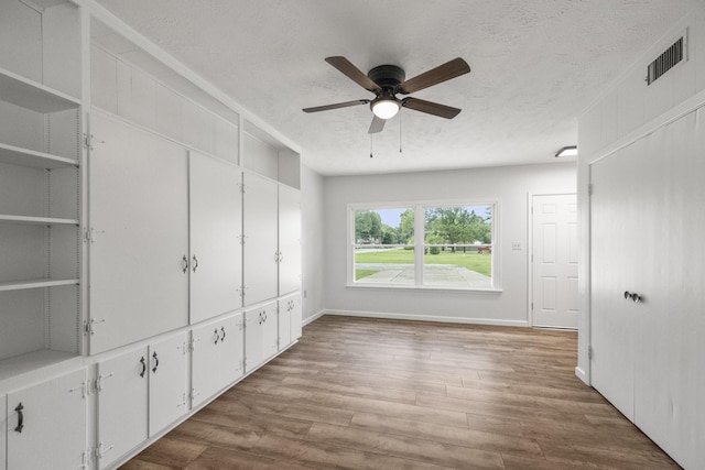 606 Clayton St, Tomball, TX 77375 - unfurnished bedroom featuring wood finished floors, a ceiling fan, baseboards, and a textured ceiling