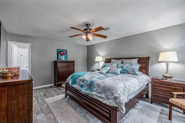 3706 Autumn Ln, Baytown, TX 77521 - bedroom featuring light wood-type flooring, a textured ceiling, baseboards, and ceiling fan