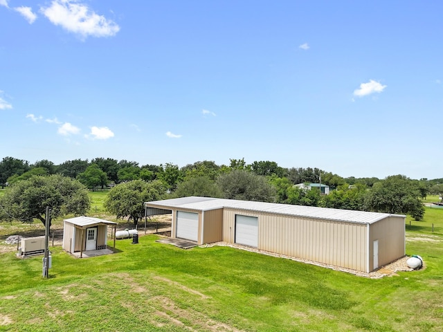 14624 Dove Ln, Needville, TX 77461 - view of green lawn with a garage, an outdoor structure, an outbuilding, and view of wooded area