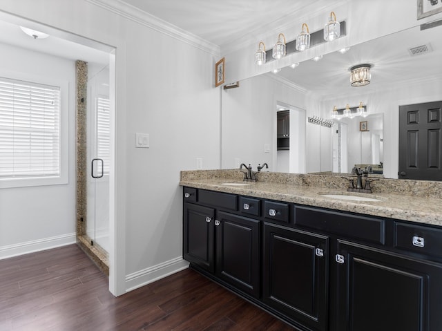 14624 Dove Ln, Needville, TX 77461 - bathroom featuring crown molding, double vanity, baseboards, a shower stall, and wood finished floors