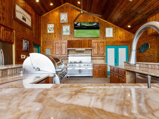 14624 Dove Ln, Needville, TX 77461 - kitchen featuring lofted ceiling, appliances with stainless steel finishes, light countertops, wooden walls, and wood ceiling