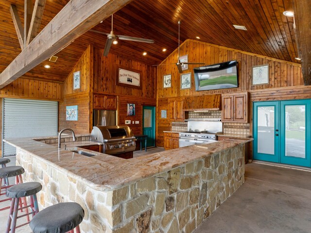 14624 Dove Ln, Needville, TX 77461 - kitchen with a sink, high vaulted ceiling, appliances with stainless steel finishes, wooden walls, and brown cabinets