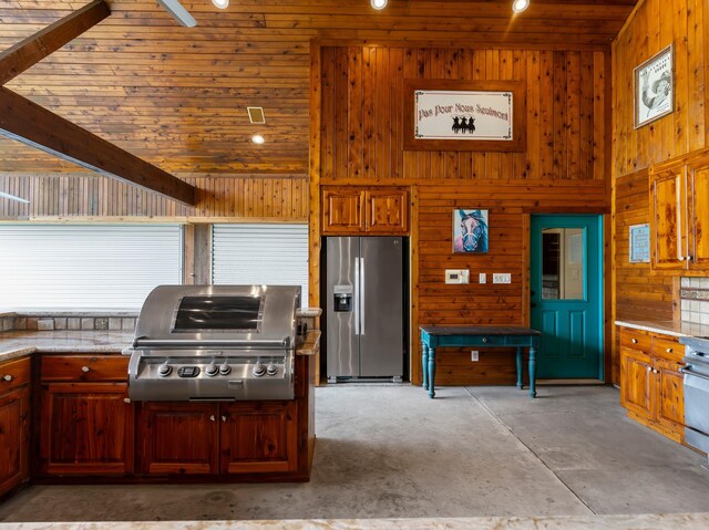 14624 Dove Ln, Needville, TX 77461 - kitchen featuring stainless steel fridge with ice dispenser, wood walls, wood ceiling, concrete flooring, and light countertops