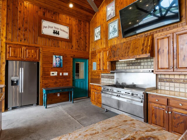 14624 Dove Ln, Needville, TX 77461 - kitchen featuring appliances with stainless steel finishes, high vaulted ceiling, wood walls, concrete floors, and tasteful backsplash