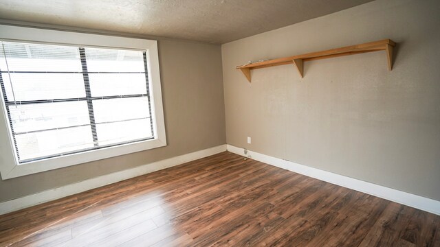 1126 Ryon St, Houston, TX 77009 - spare room featuring dark wood finished floors, a textured ceiling, baseboards, and healthy amount of natural light
