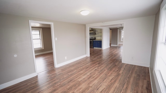 1126 Ryon St, Houston, TX 77009 - empty room with dark wood-style floors, baseboards, and a chandelier