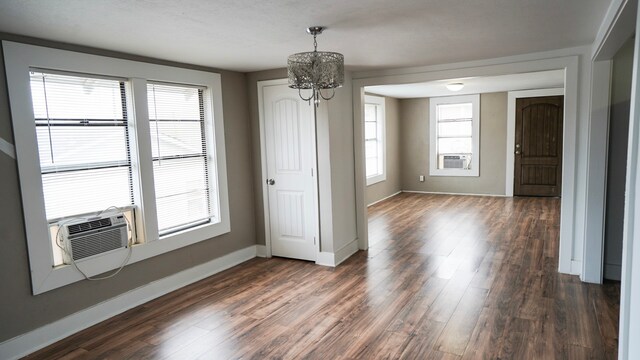 1126 Ryon St, Houston, TX 77009 - unfurnished dining area with a chandelier, dark wood-style floors, baseboards, and cooling unit